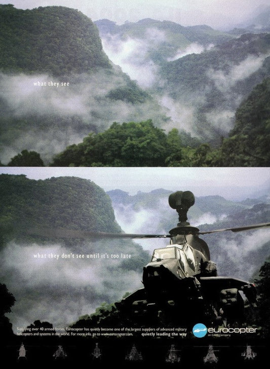 A two-part image; the top shows a serene, foggy green mountain landscape with the text "what they see." The bottom reveals a military helicopter emerging through the fog with the text "what they don't see until it's too late." Printed on long-lasting, high-quality FSC-certified paper, this Eurocopter sales Ad by Warfare Media has their logo placed at the bottom right.